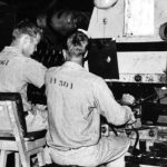 Work inside Shirt Factory Building - two men working in License Plate Factory.