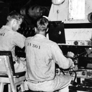 Work inside Shirt Factory Building - two men working in License Plate Factory.