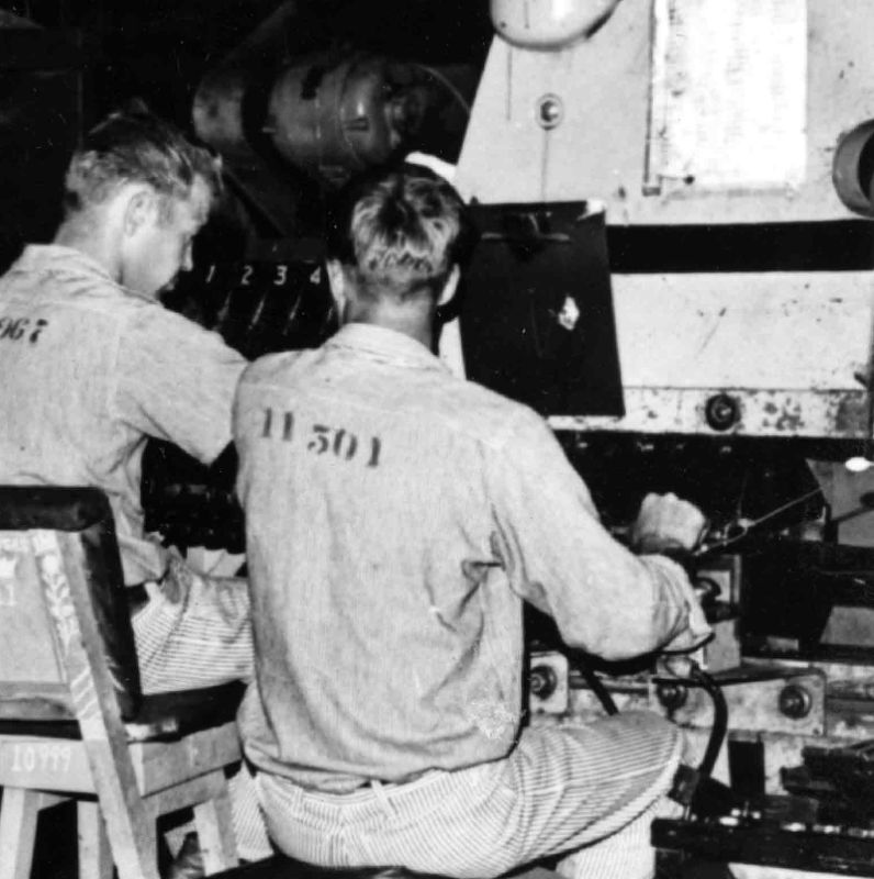 Work inside Shirt Factory Building - two men working in License Plate Factory.