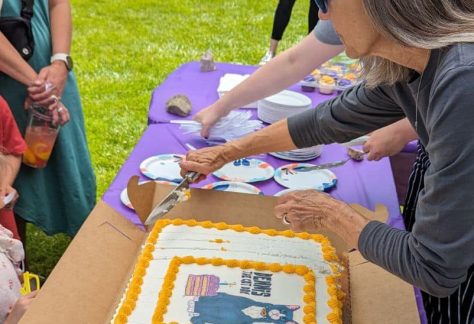 Staff cutting cake for Dennis the Cat Day