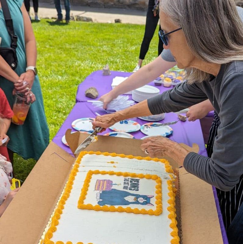 Staff cutting cake for Dennis the Cat Day