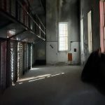 A cell block at the Old Idaho Penitentiary with drastic shadows and low light.