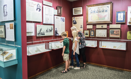 Two Kids and Adult Looking at an Exhibit