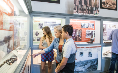 Young Adults and Child Looking at Old Pen Exhibit